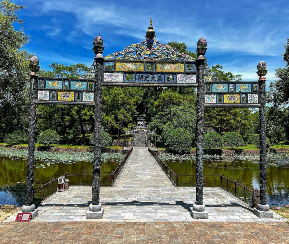 The bridge spans across the cool, green lake shore